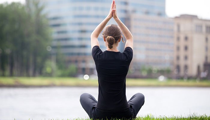 Woman doing yoga in front of an office building
