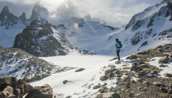 a woman hiking in snow covered mountains 