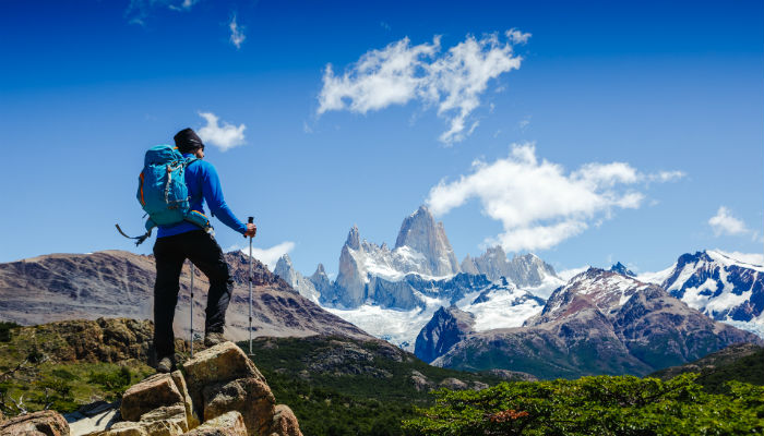 man in blue clothes hiking in the mountains 