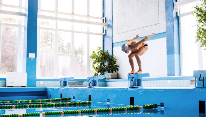 man diving into swimming pool