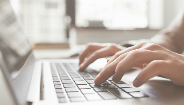 hands typing on a laptop