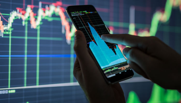Businessman checking stock market data using a mobile phone