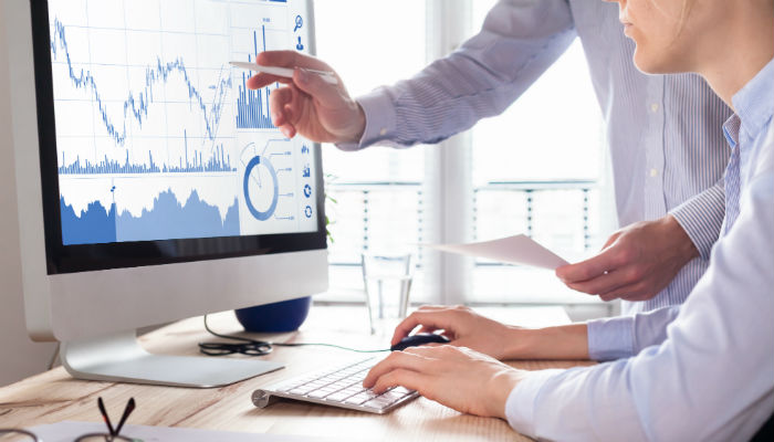 two people looking at investment chart on computer