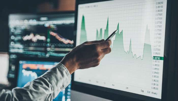  Close-up of young businessman pointing on the data presented in the chart on a computer screen