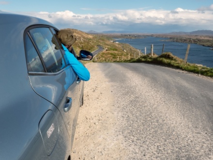 man looking out car window