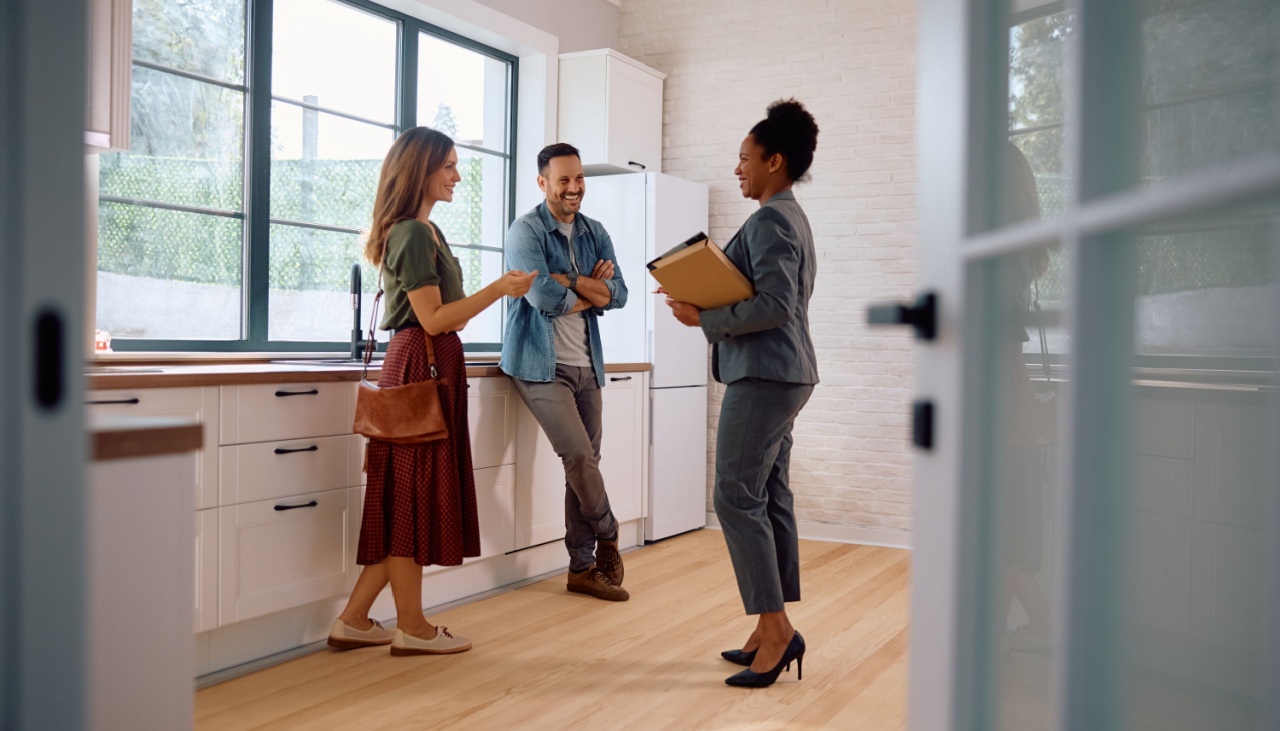 Young couple viewing house with estate agent