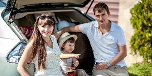 family sitting at back of car