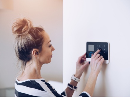 woman setting home alarm
