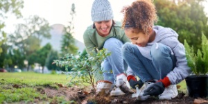 mother and daughter planting a tree
