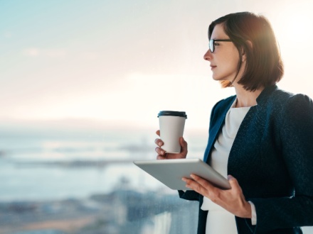 woman with coffee and tablet