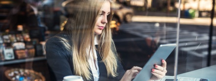 woman reading newspaper in coffee shop