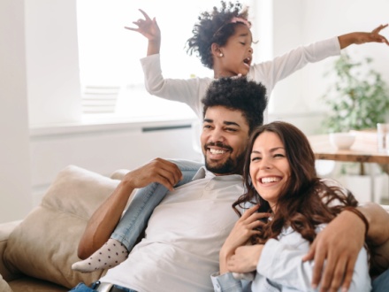 happy parents at home playing with child