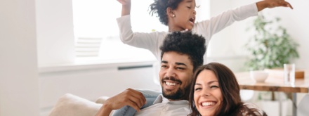 happy parents at home playing with child