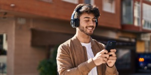 young man with headphones and phone in hand