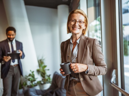 older female office worker with male colleague in the background
