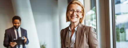 older female office worker with male colleague in the background
