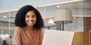 African woman at desk with laptop
