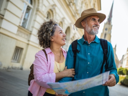 Middle aged couple on city break reading a map