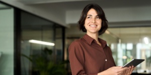 Hispanic woman in office on tablet