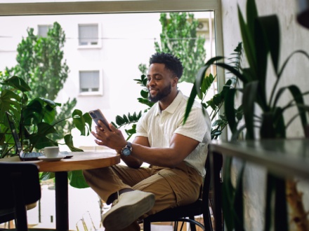 man in coffee shop surrounded by plants