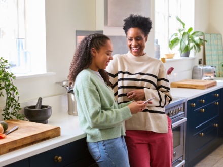 Mother and daughter in kitchen chatting