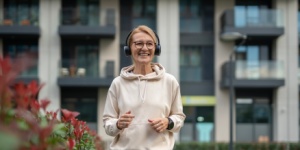older woman walking with headphones