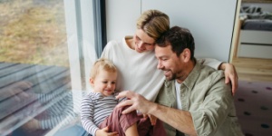 young family at home sitting by the window