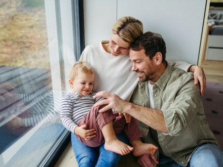 young family at home sitting by the window
