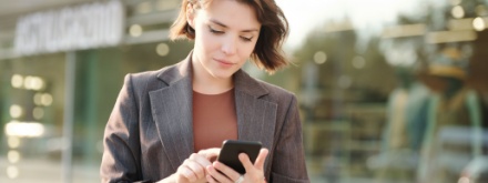 young business woman typing on her phone