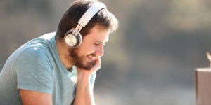 man with wireless headphones watching media content on tablet