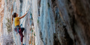 female rock climbing climbing side of rock