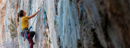 female rock climbing climbing side of rock