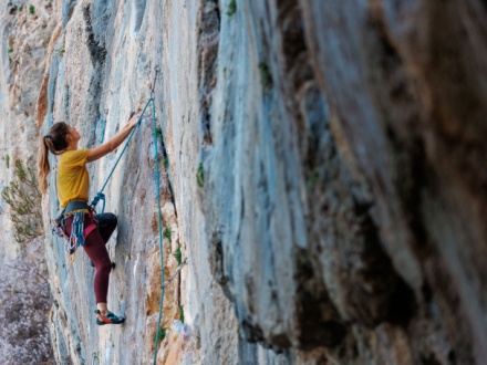 female rock climbing climbing side of rock