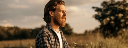 man sitting in field meditating