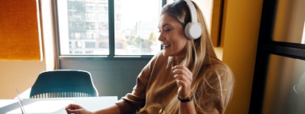 smiling woman in office with headphones
