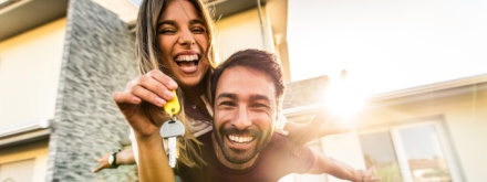 happy young couple holding home keys