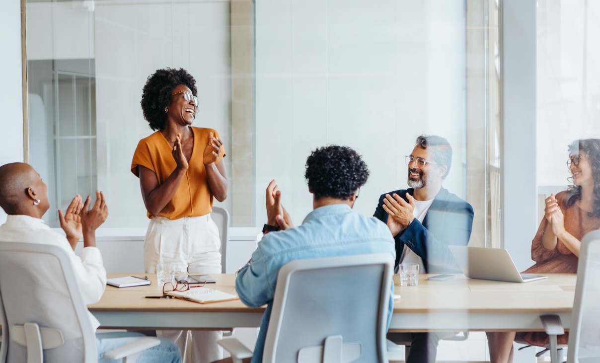Group of diverse office workers clapping hands in a meeting
