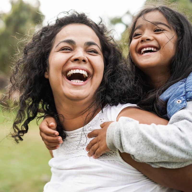 mother and daughter laughing in park