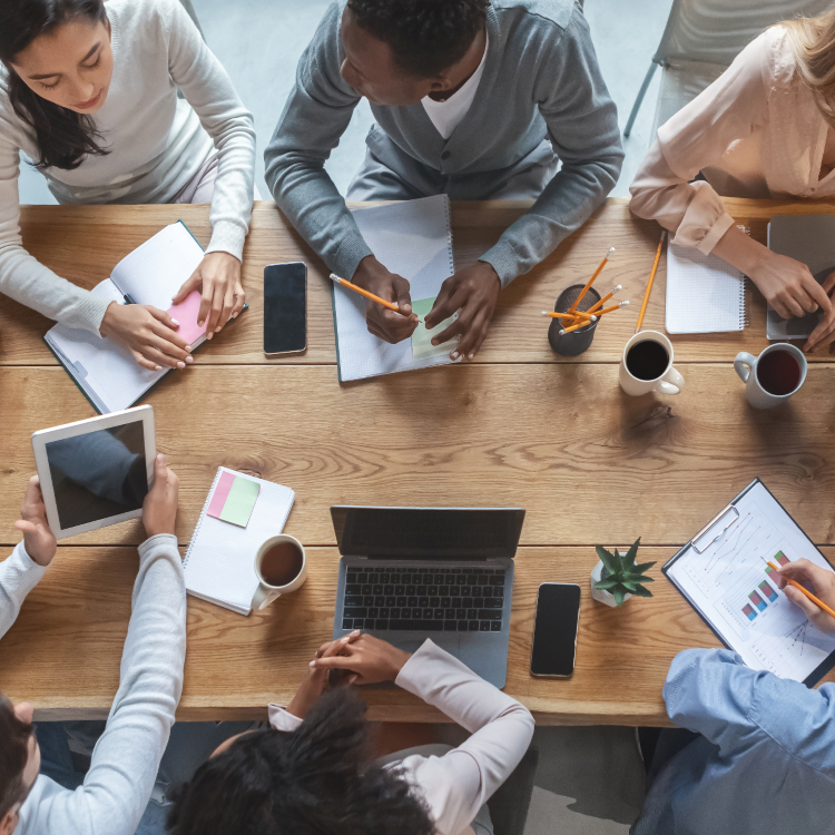 Group of colleagues at able with laptop