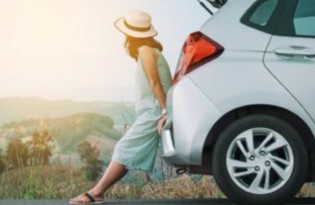 woman sitting at the back of a white car