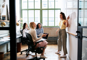 team meeting with girl at whiteboard