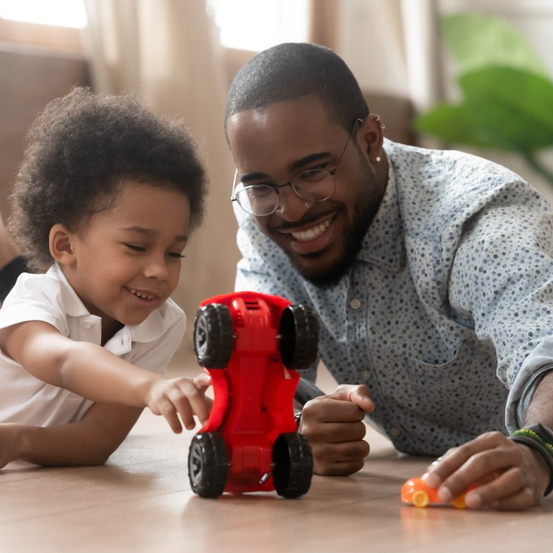 father and son playing with toy car