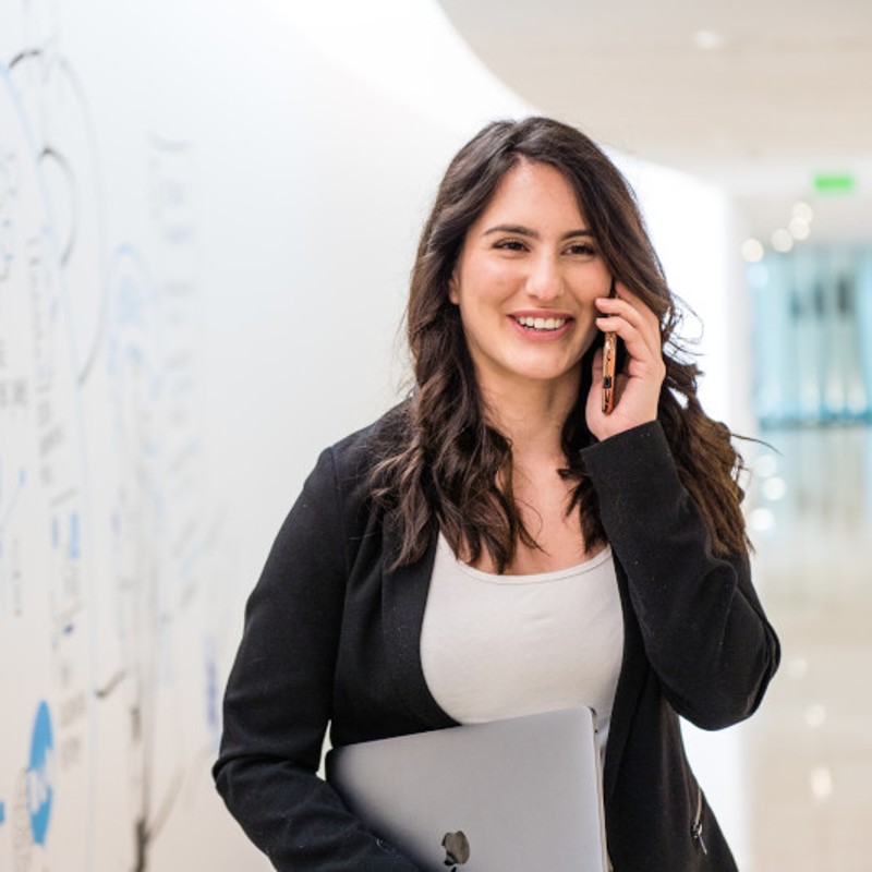 woman walking and talking on phone in office