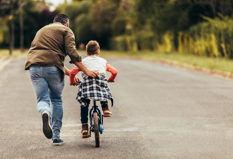 Father teaching child to ride a bike