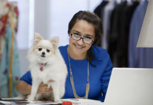 Woman at desk with small dog