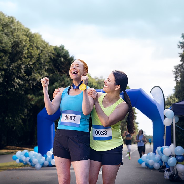 Two women celebrating at the end of a run