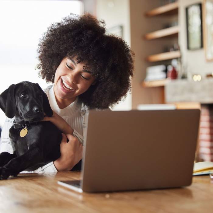 woman at home with dog and laptop