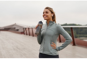 young woman running holding water bottle