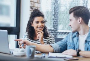 two young people talking in office