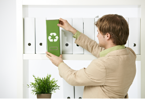 man taking green folder from shelf